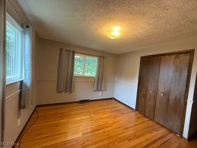 Upstairs bedroom with wood flooring, a ceiling light and a closet