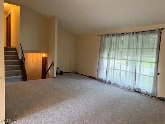 Living room with new carpet and vaulted ceiling