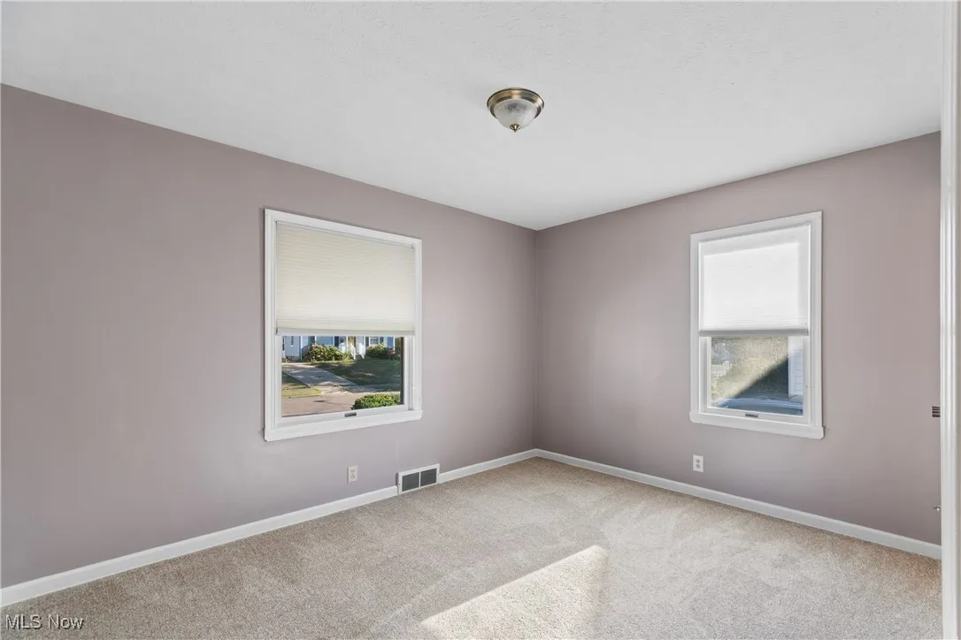 Carpeted empty room featuring baseboards