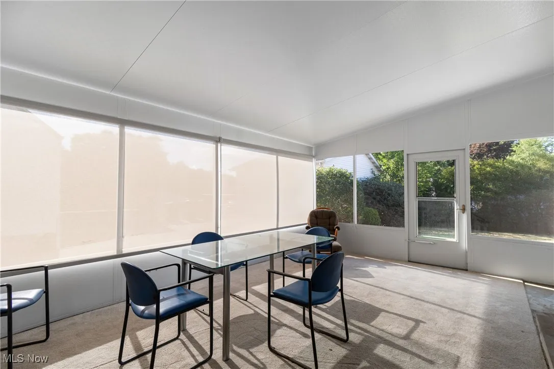 Sunroom / solarium featuring vaulted ceiling and carpet floors