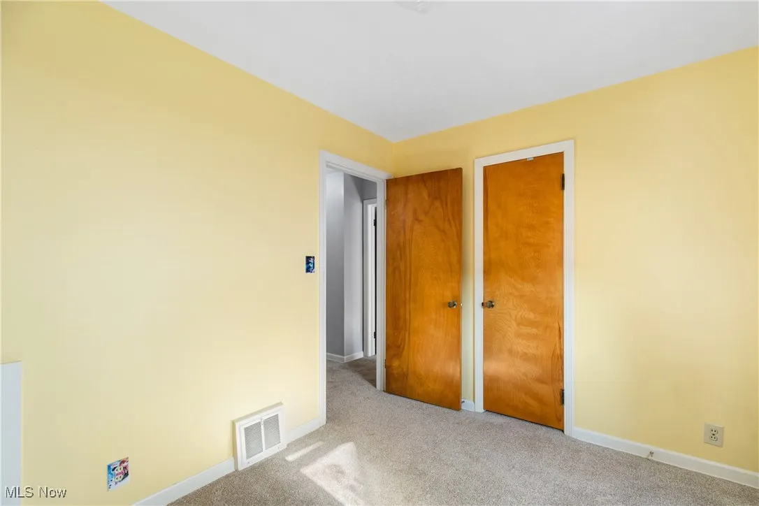 Unfurnished bedroom with light carpet and a closet