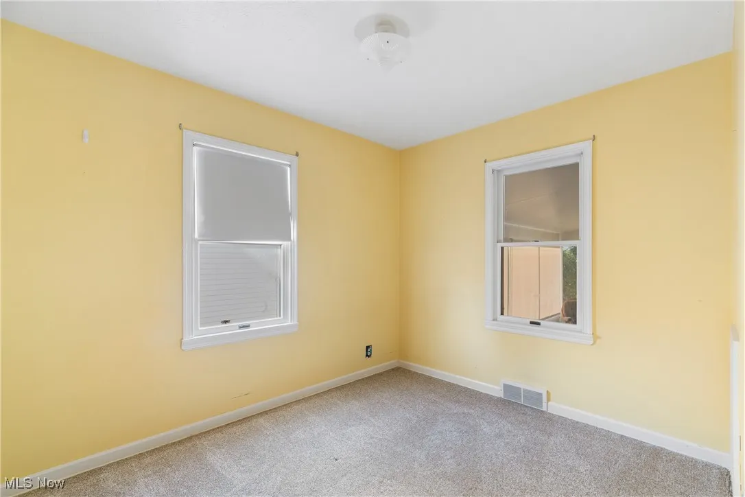 Carpeted empty room featuring baseboards
