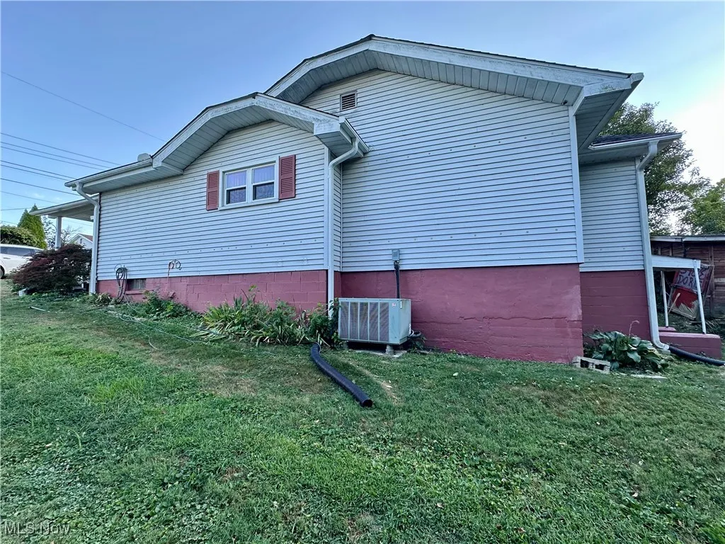 Side view of home featuring a yard
