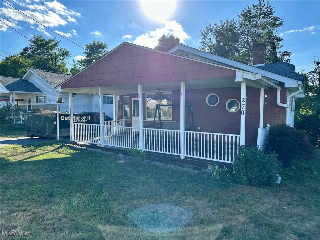 Front view of home with covered porch, and a front yard
