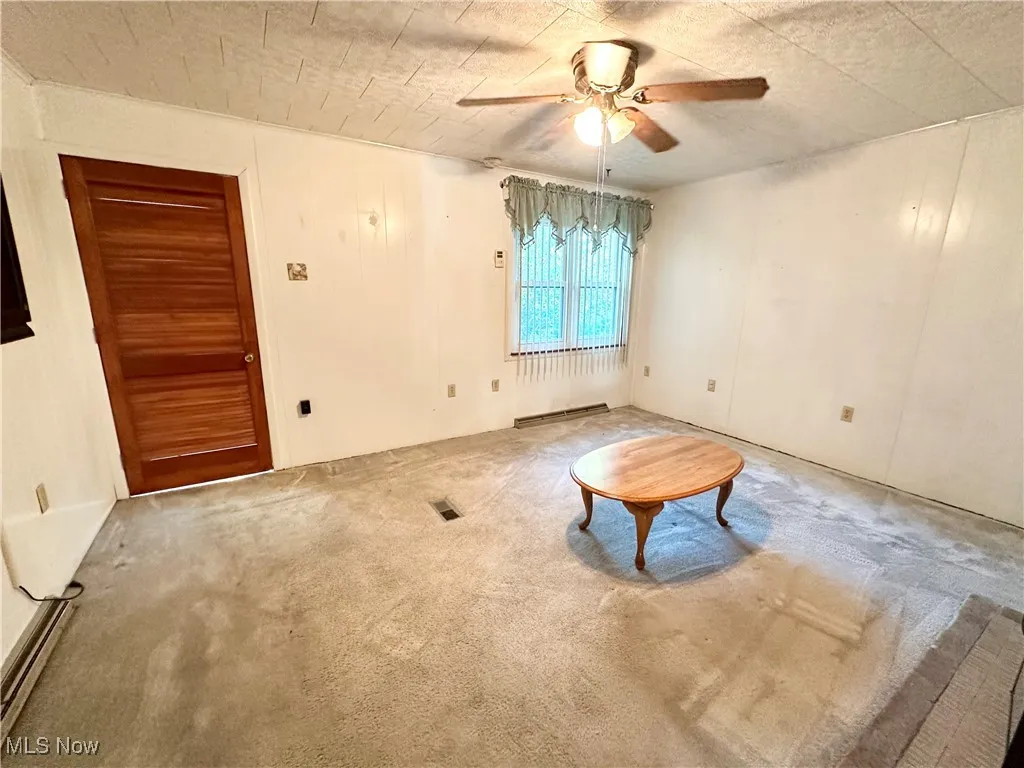 Living room with carpet floors and a ceiling fan
