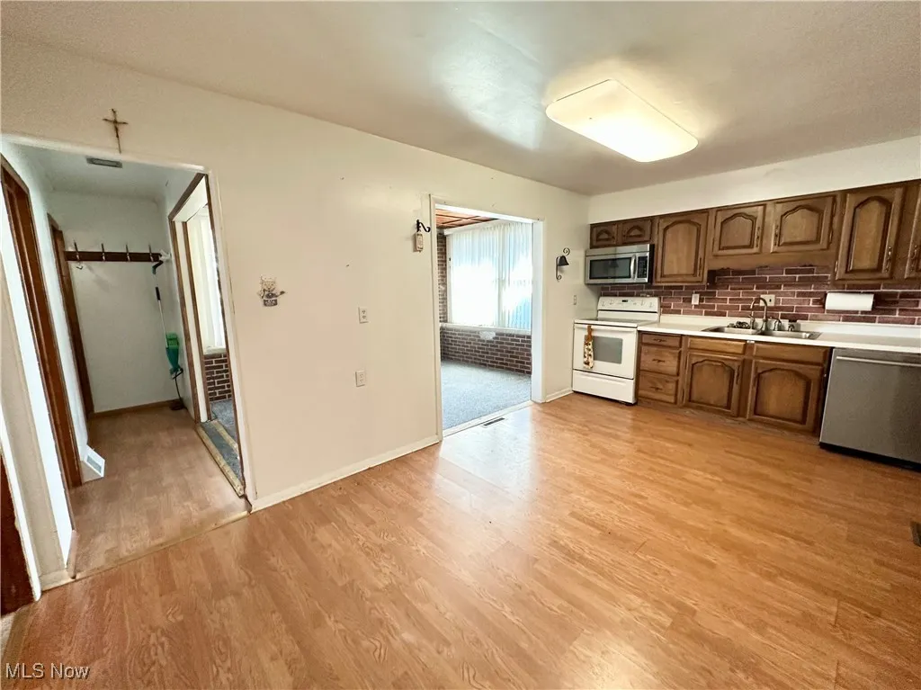 Kitchen featuring appliances, wood finished floors, and cabinets
