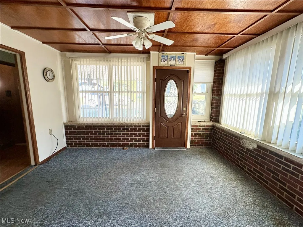 Foyer with plenty of natural light, carpet floors, and ceiling fan