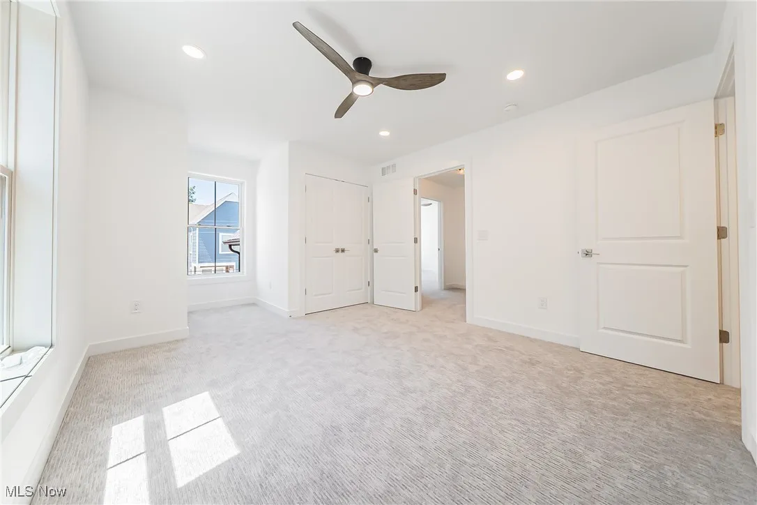 Bedroom with light colored carpet, recessed lighting, and a ceiling fan
