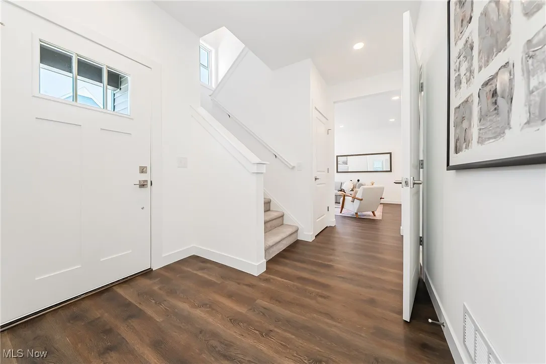 Entryway featuring dark wood-style floors, recessed lighting, and stairway