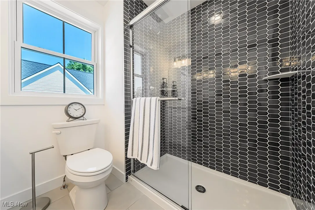 Bathroom featuring a shower stall and light tile patterned floors