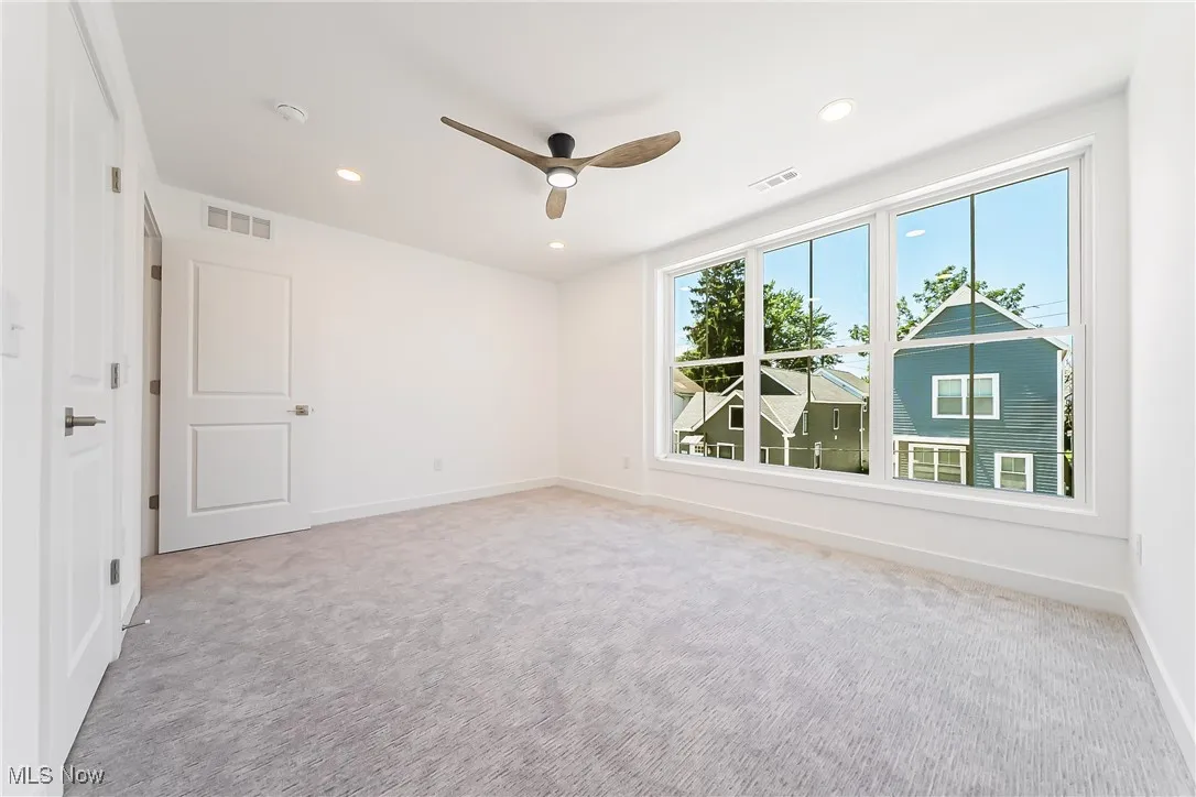 Bedroom with light colored carpet, recessed lighting, and a ceiling fan