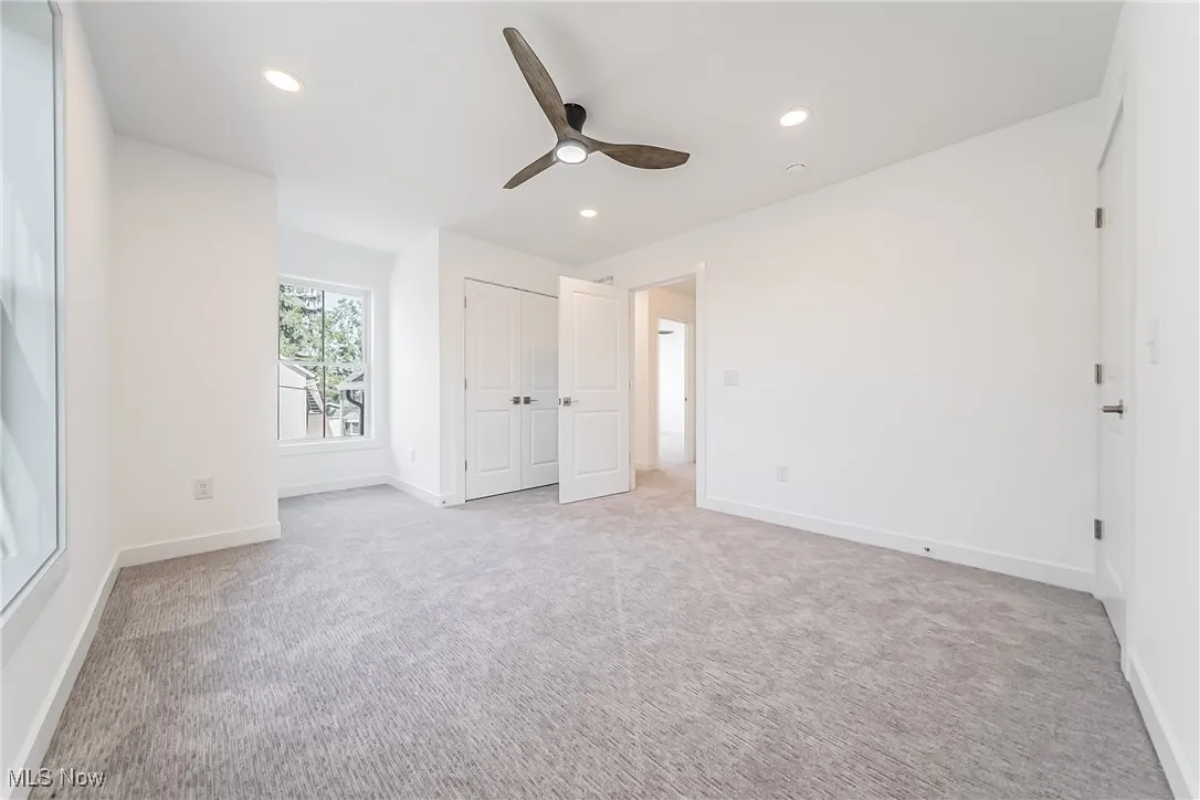 Bedroom featuring light colored carpet, recessed lighting, a ceiling fan, and a closet