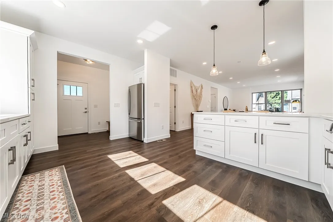 Kitchen featuring white cabinets, pendant lighting, recessed lighting, freestanding refrigerator, and dark wood-style flooring