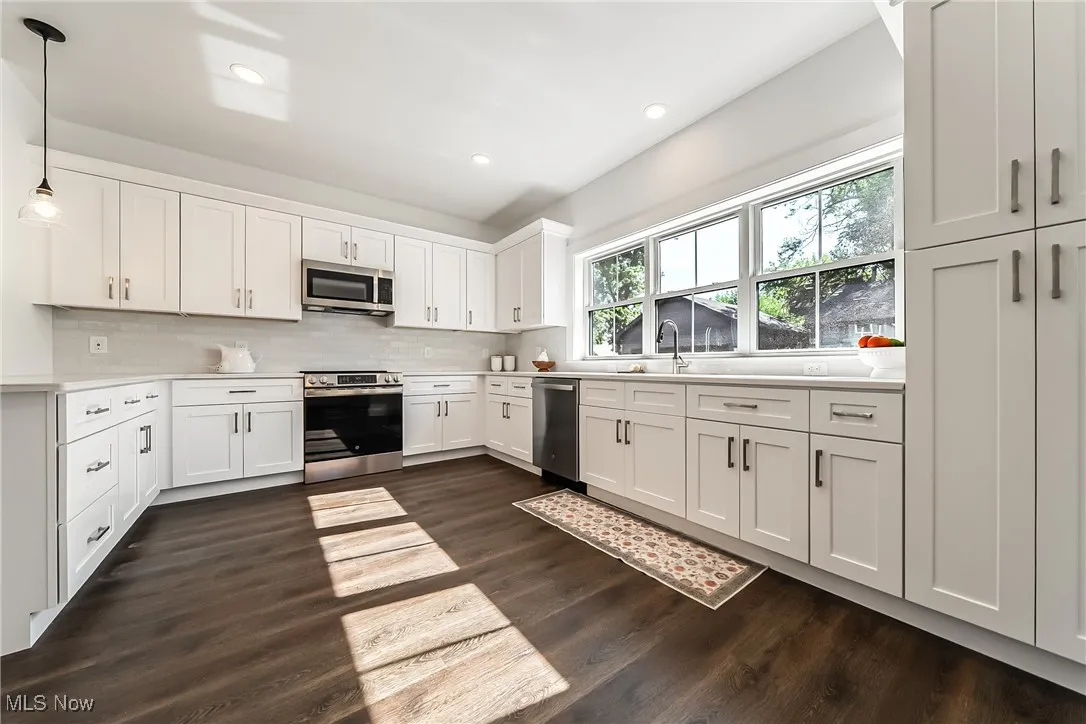 Kitchen with white cabinets, pendant lighting, stainless steel appliances, decorative backsplash, and recessed lighting