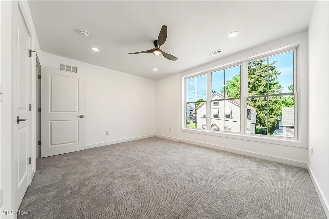 Carpeted bedroom with recessed lighting and a ceiling fan