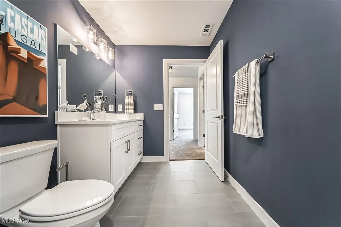 Bathroom featuring vanity and dark tile patterned flooring