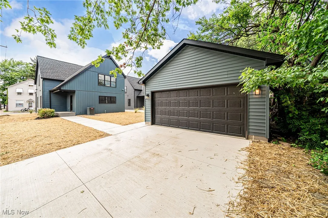 View of back yard featuring a garage and a concrete driveway
