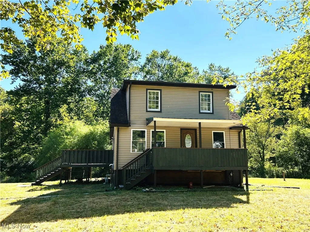 Front view of home featuring stairs, a deck, a porch and a front yard