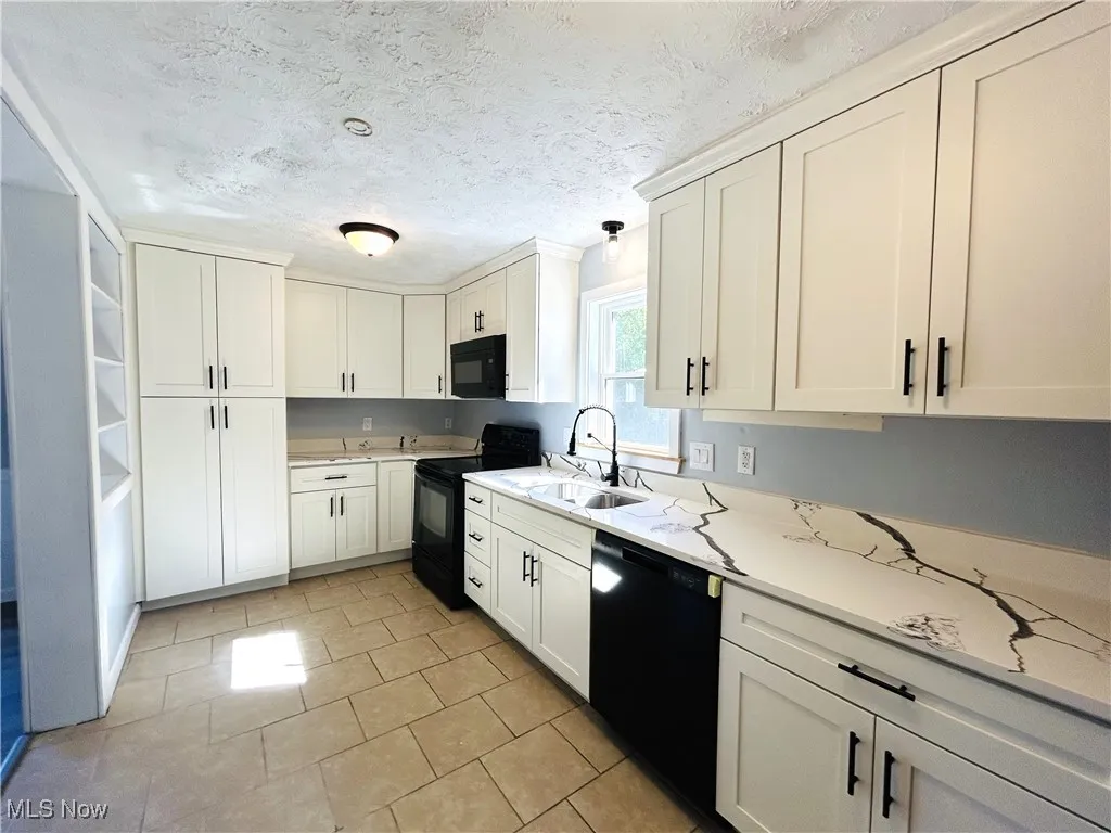 Kitchen featuring appliances and white cabinetry