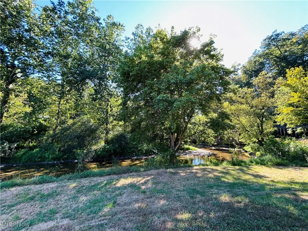 Back view of yard featuring a water view