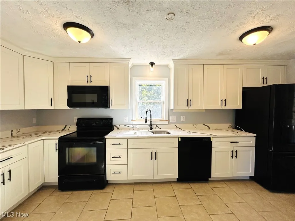 Kitchen featuring appliances and white cabinets