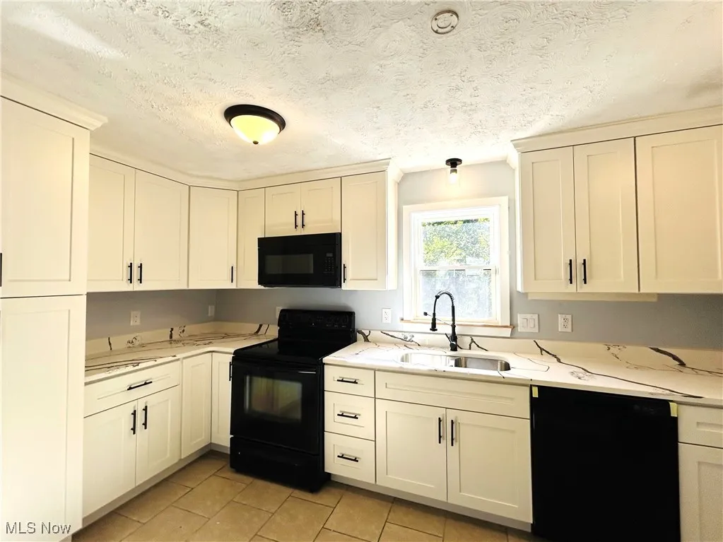 Kitchen featuring appliances and white cabinets