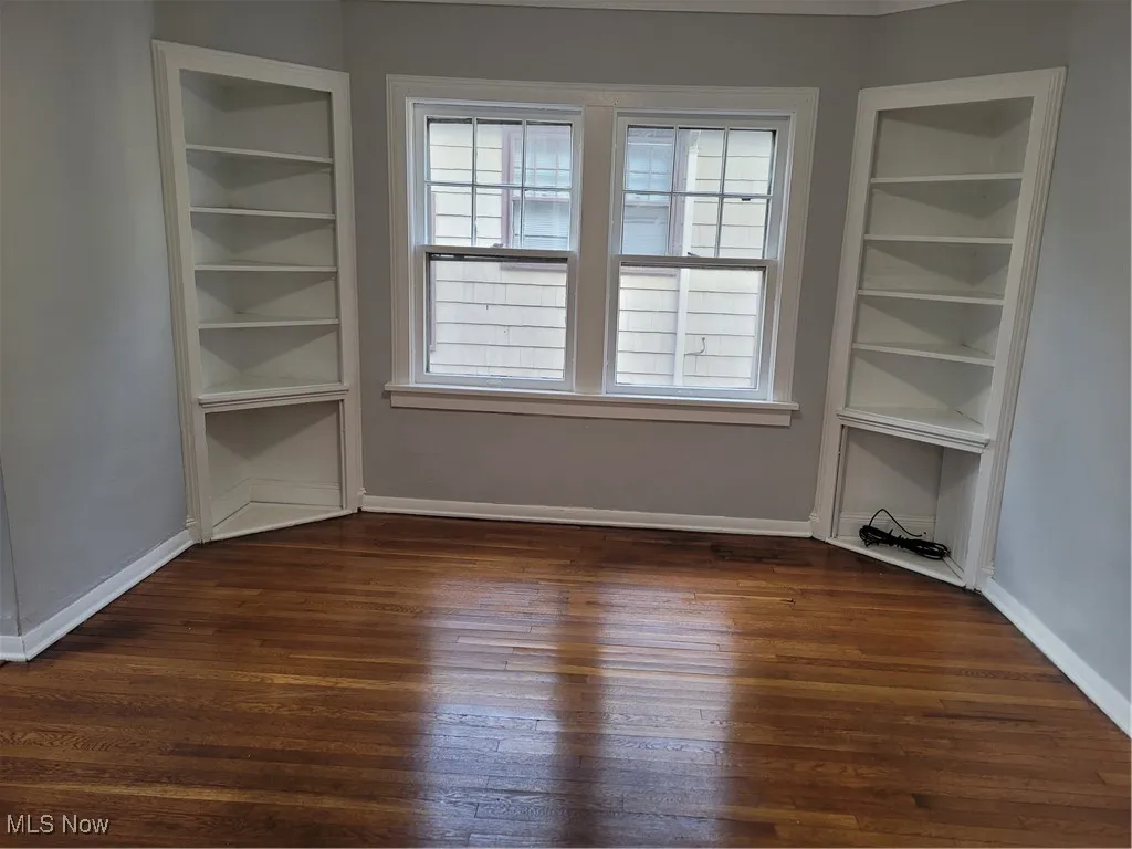 Spare room featuring dark wood finished floors and baseboards