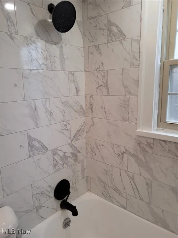 Bathroom featuring shower / washtub combination and toilet