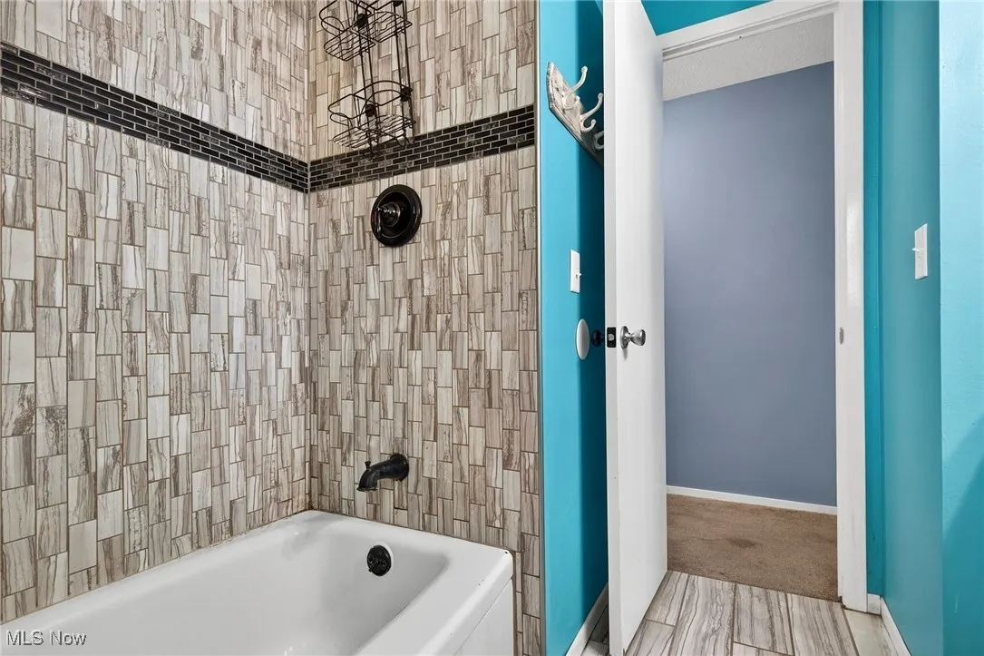 Bathroom featuring baseboards and shower / washtub combination