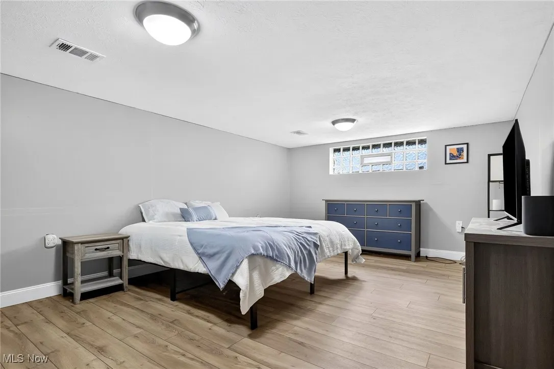 Bedroom with light wood-style flooring and a textured ceiling