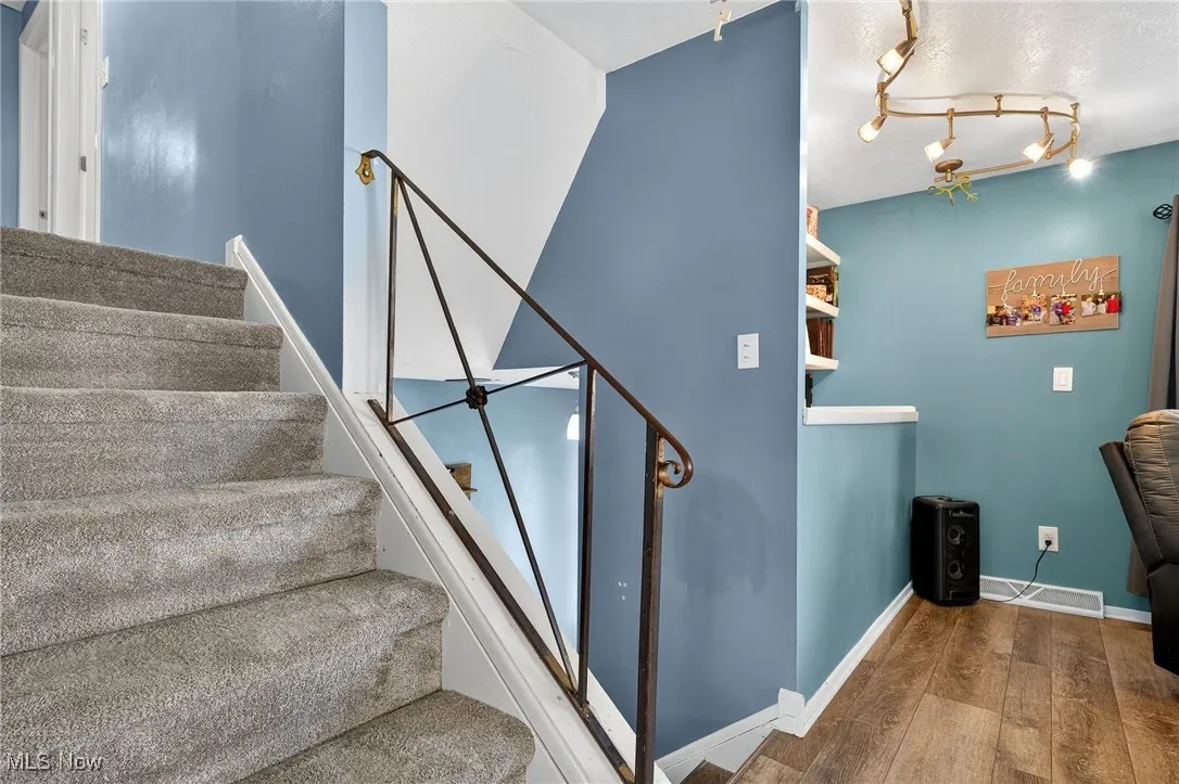 Stairway featuring baseboards and hardwood / wood-style flooring