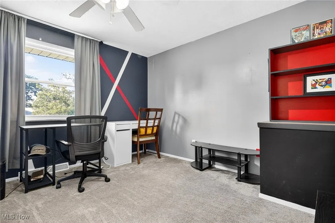 Office space featuring light colored carpet and a ceiling fan