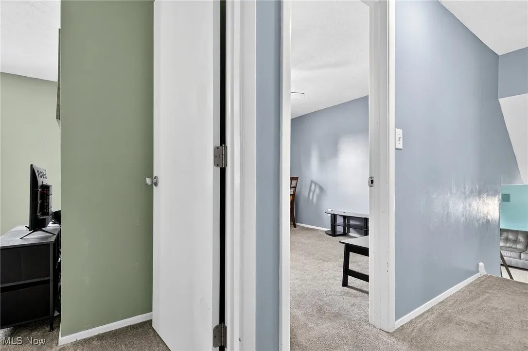 Corridor featuring carpet and baseboards