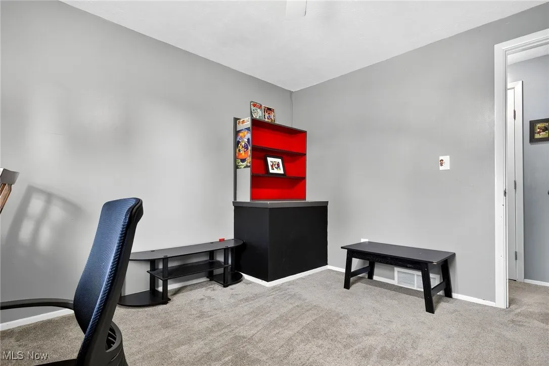 Home office with light carpet and baseboards
