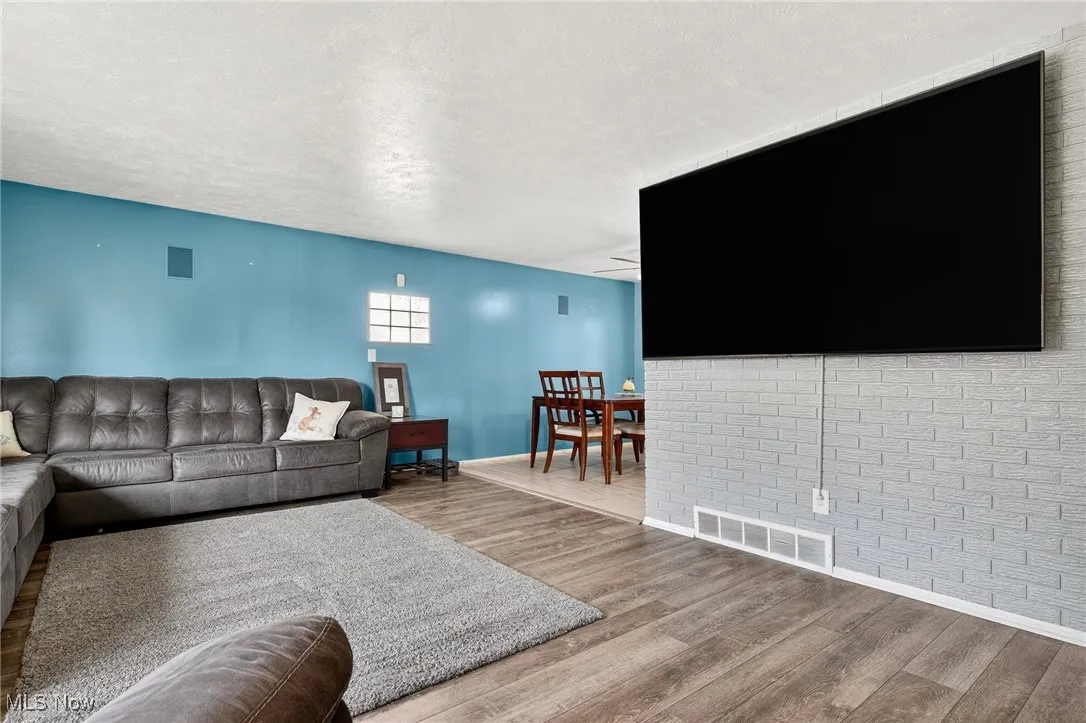 Living area with wood finished floors and a textured ceiling