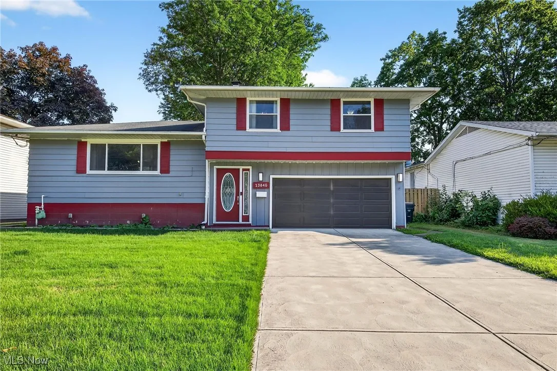 Split level home featuring an attached garage, a front yard, and driveway