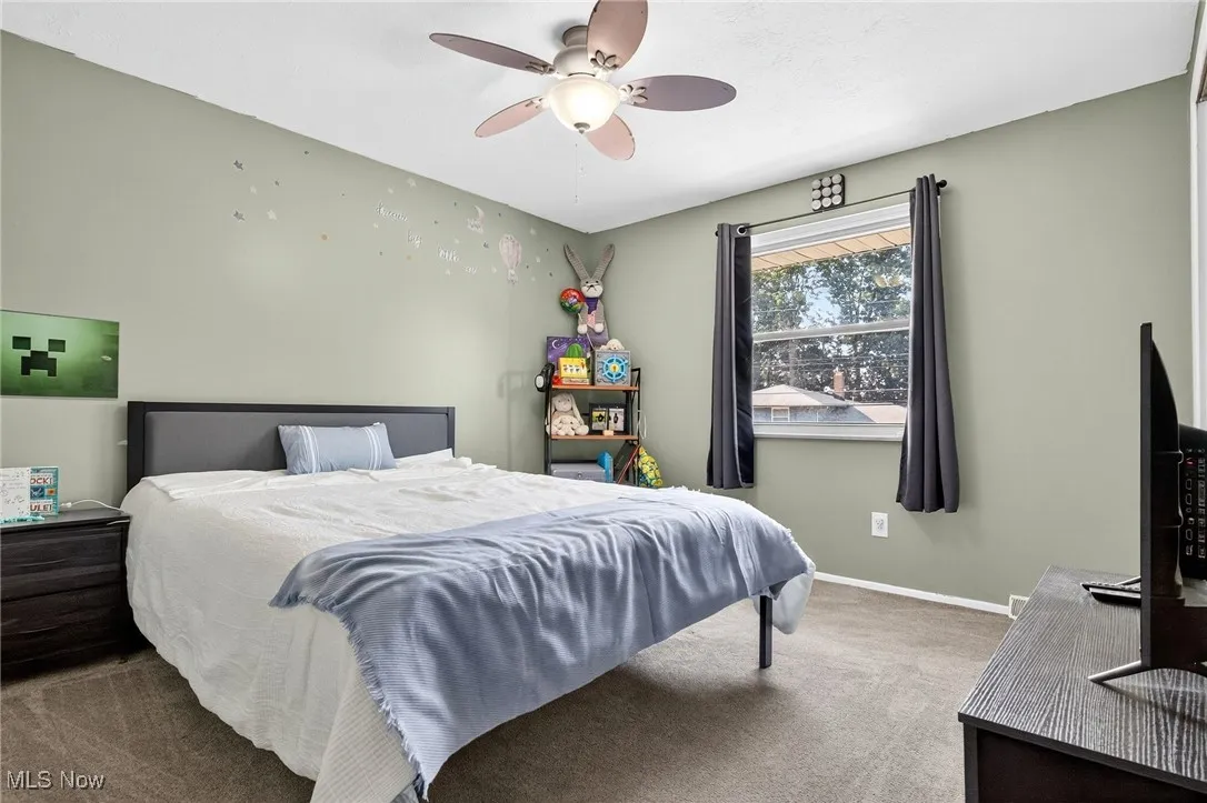 Carpeted bedroom featuring baseboards and ceiling fan