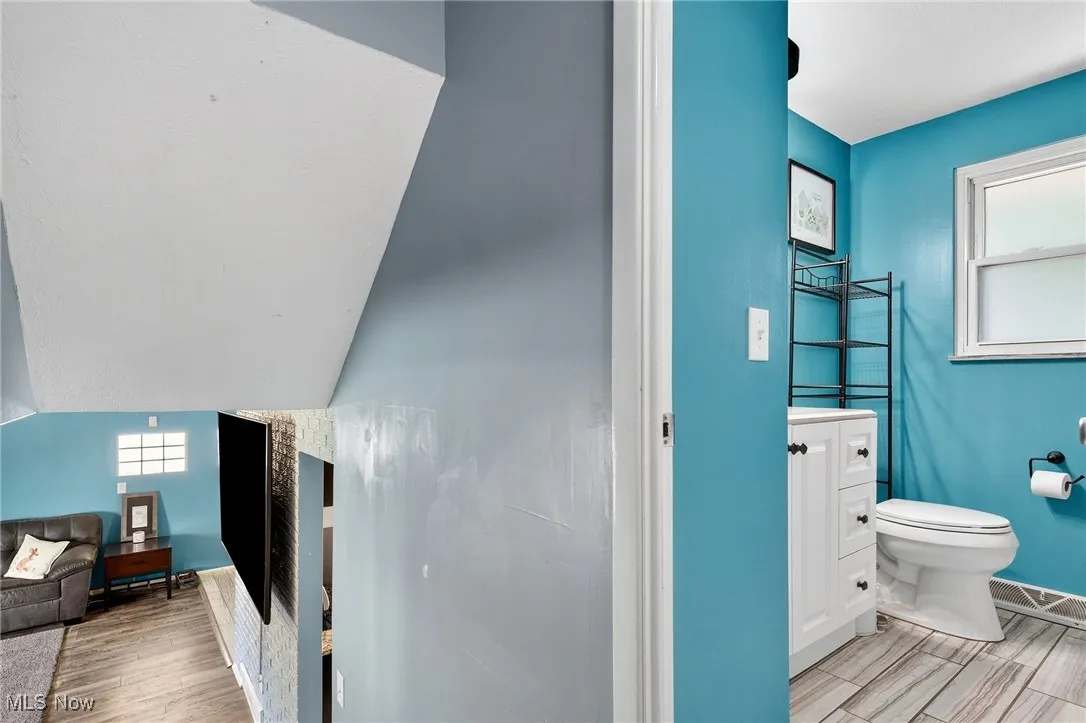 Half bath with wood finish floors and vanity