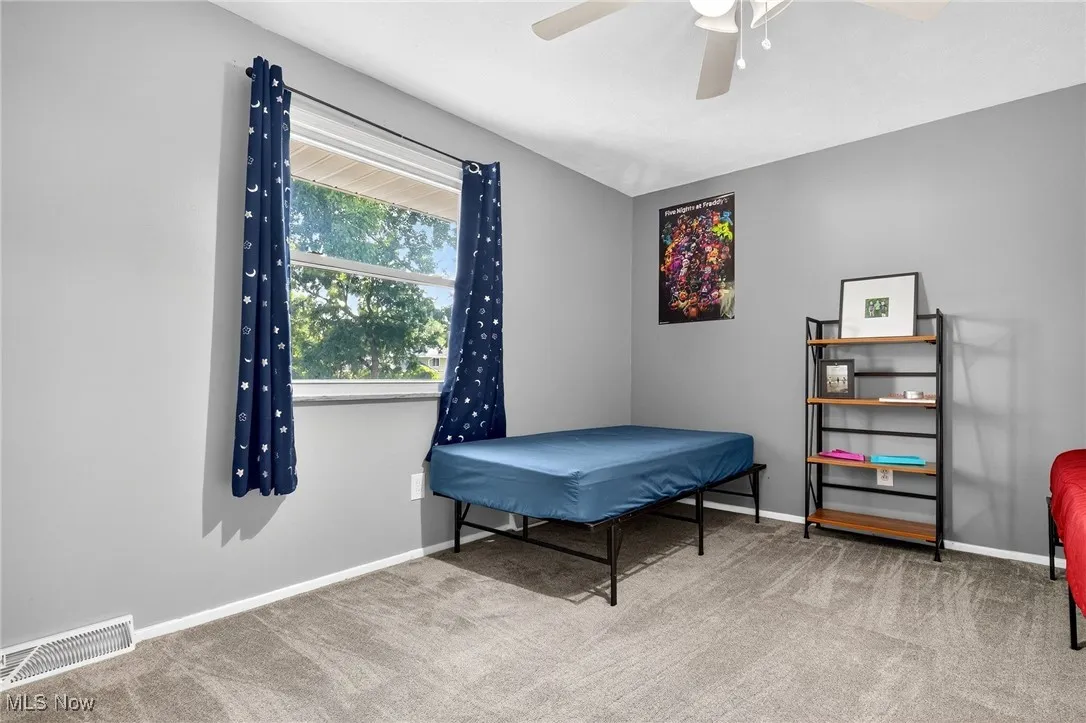 Bedroom featuring light colored carpet and a ceiling fan