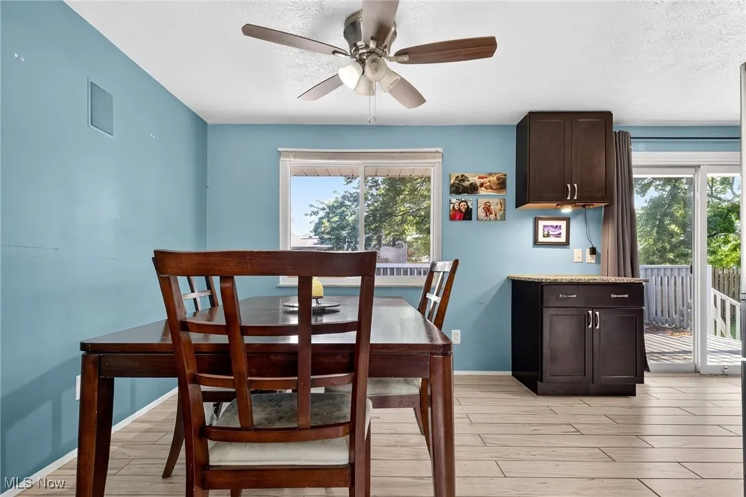 Dining area with light wood-style floors, plenty of natural light, a textured ceiling, and ceiling fan