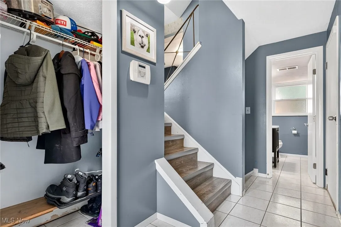 Stairs featuring tile patterned flooring and lofted ceiling