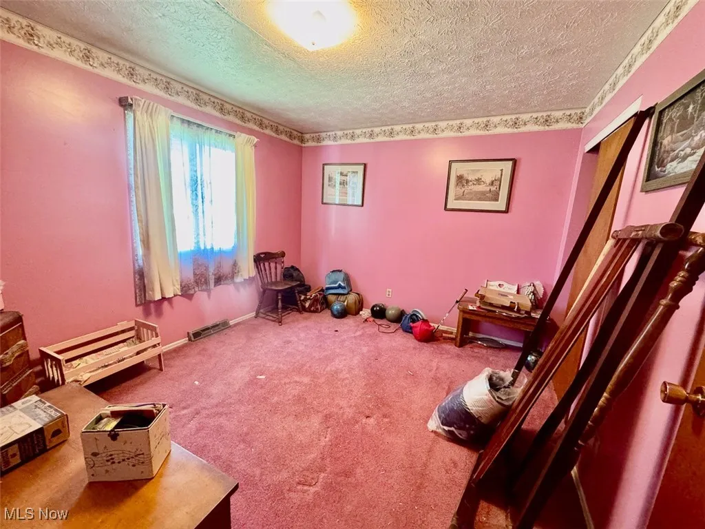 Bedroom featuring carpet floors and a textured ceiling