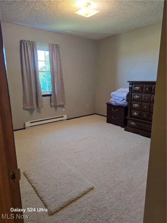 2nd bedroom featuring carpet, and a textured ceiling