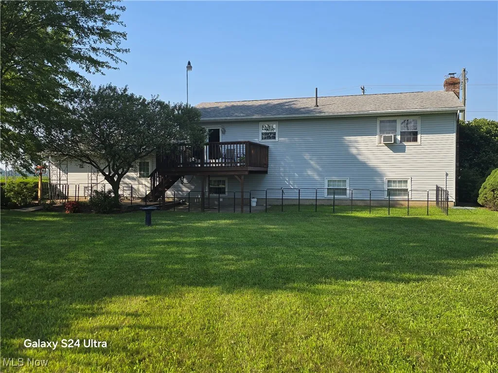 Back of property with a deck and a chimney