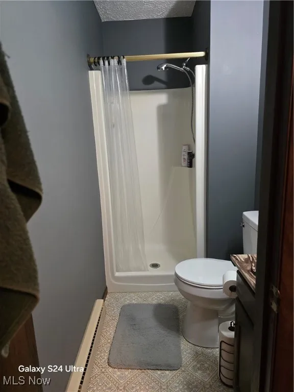 Master bathroom with a textured ceiling, a shower stall, and vanity.