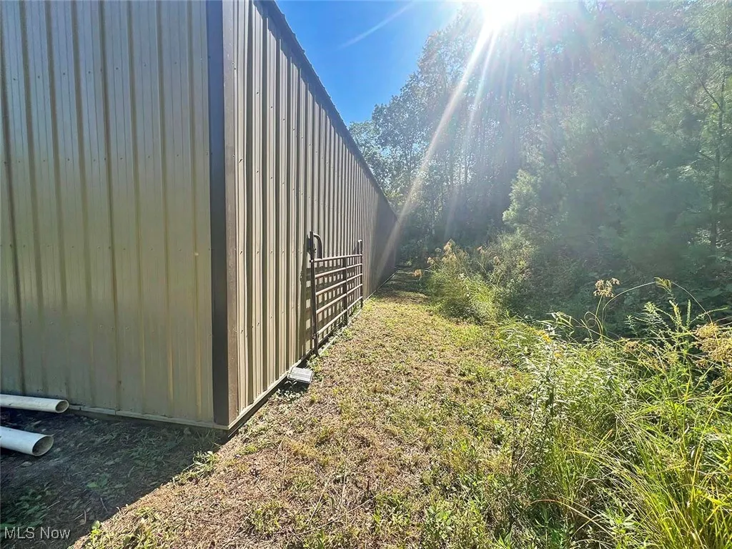 View of side of property featuring a wooded view