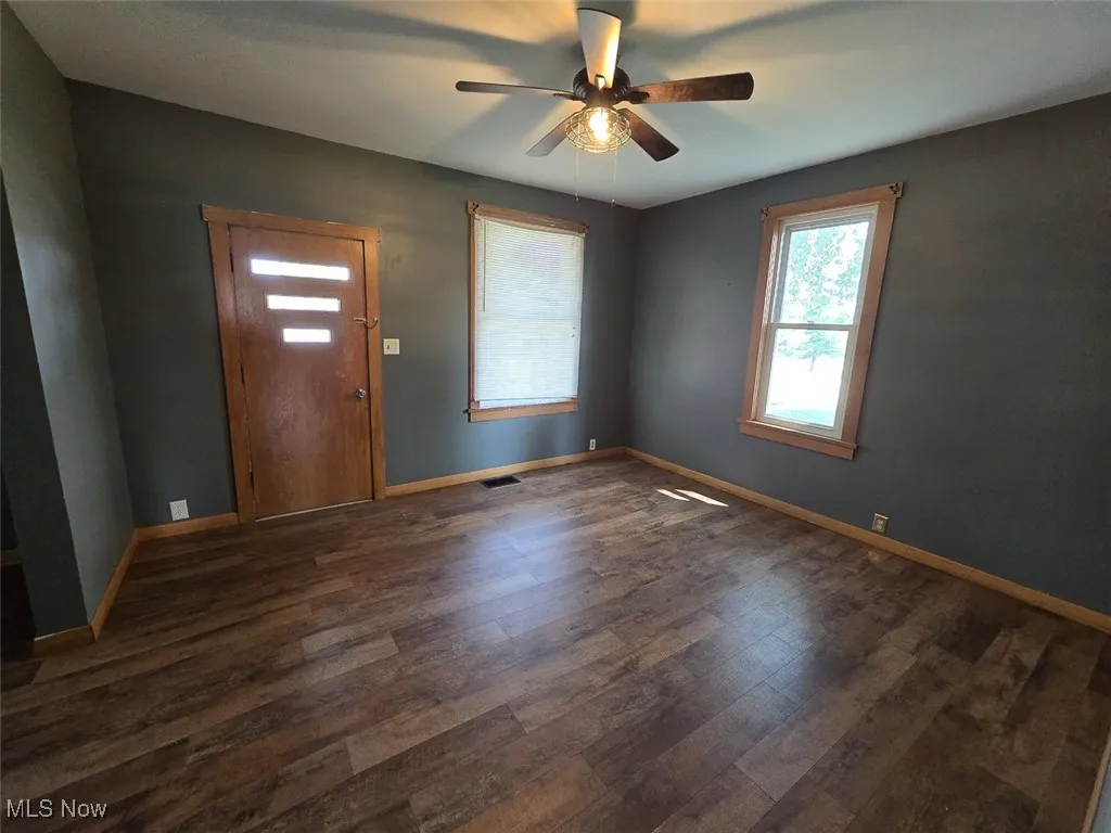 Foyer with a ceiling fan and dark wood finished floors