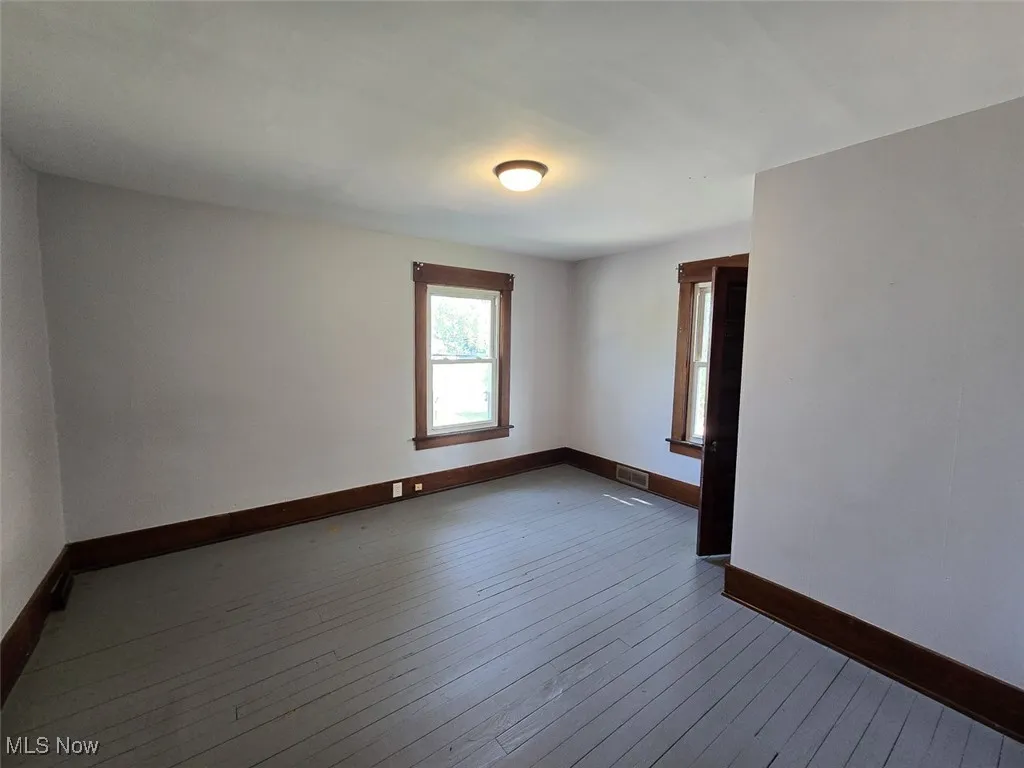 Spare room featuring baseboards and hardwood / wood-style floors
