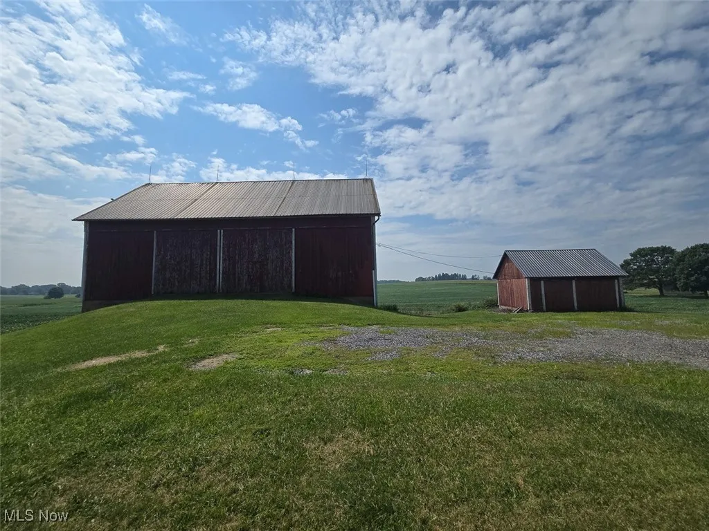 View of pole building with a yard and a view of rural / pastoral area