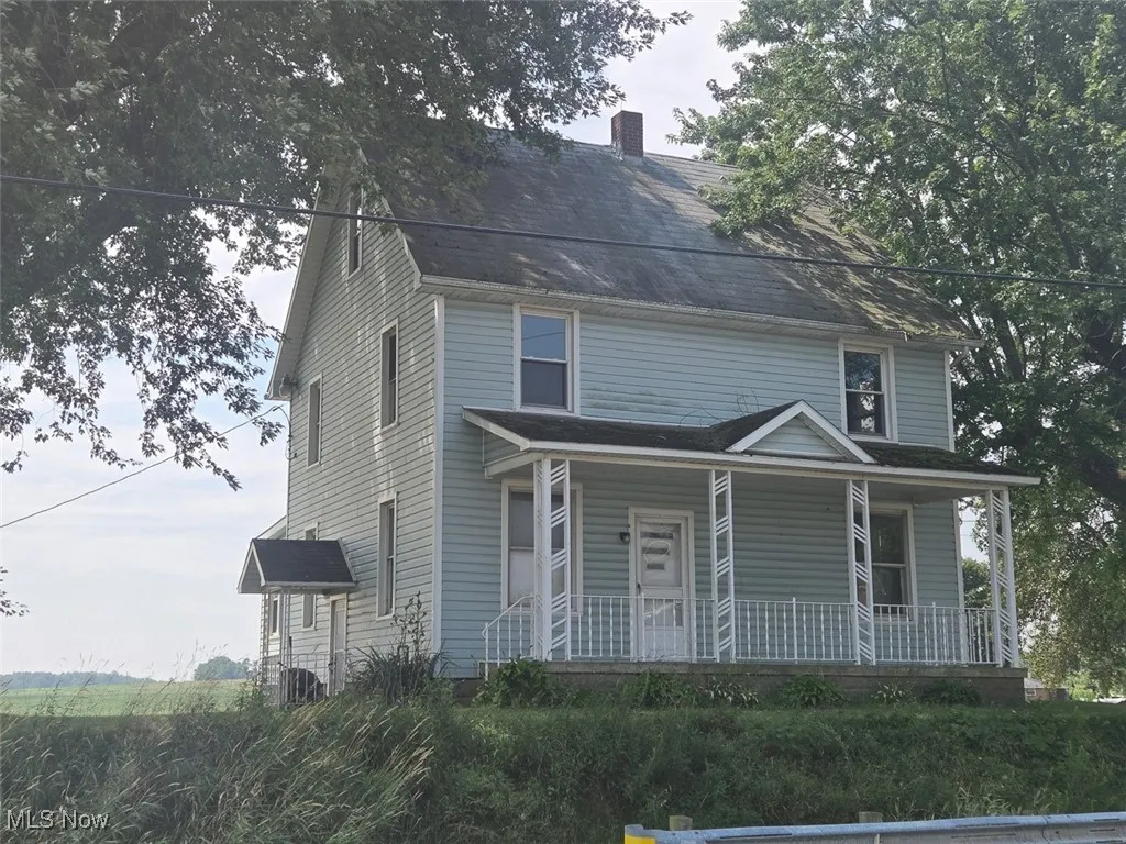 View of front of house with a porch, a chimney, and a shingled roof